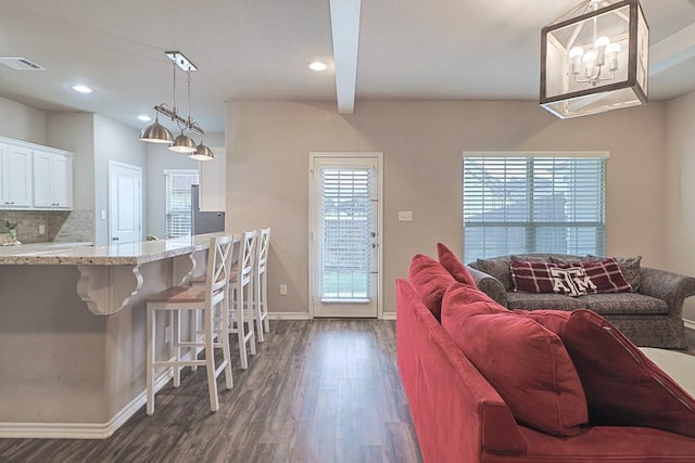 living room with dark hardwood / wood-style flooring and beam ceiling