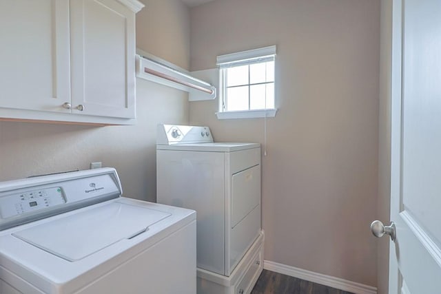 laundry room with cabinets, independent washer and dryer, and dark wood-type flooring