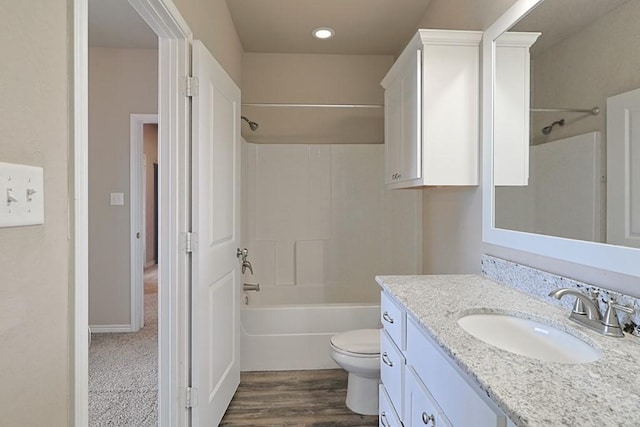 full bathroom with hardwood / wood-style floors, vanity, bathing tub / shower combination, and toilet