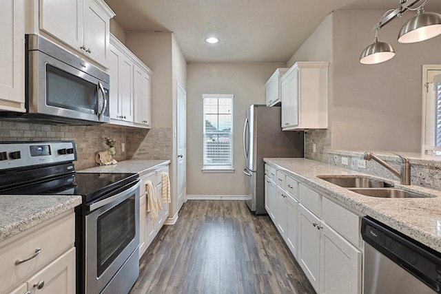 kitchen featuring white cabinetry, stainless steel appliances, sink, and pendant lighting