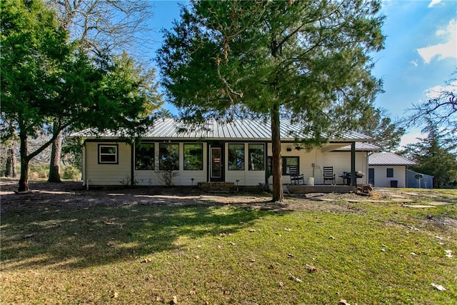 view of front of home with metal roof, a standing seam roof, and a front yard