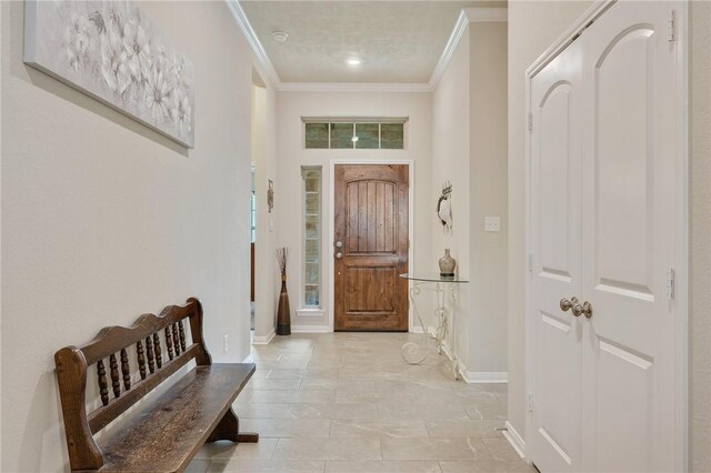 foyer entrance with baseboards and ornamental molding