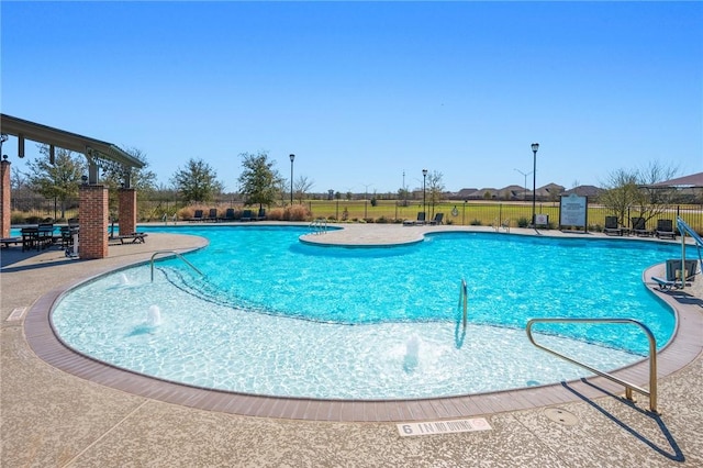 community pool featuring a patio and fence