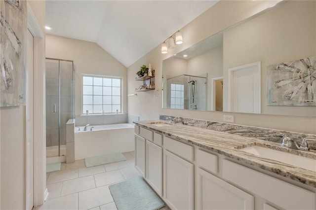 full bath featuring a shower stall, double vanity, a sink, a garden tub, and lofted ceiling