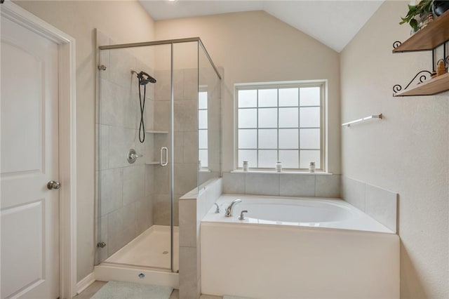full bathroom featuring lofted ceiling, a garden tub, and a shower stall