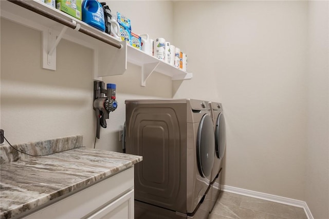 laundry room featuring light tile patterned floors, washing machine and dryer, laundry area, and baseboards