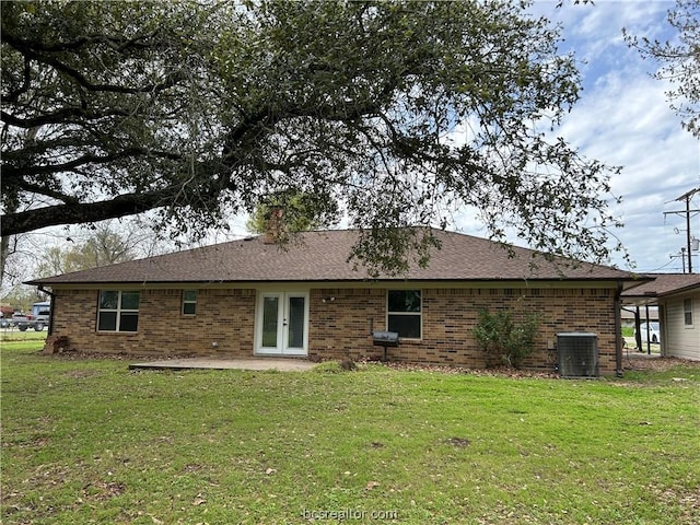 back of house featuring cooling unit, a patio area, and a lawn