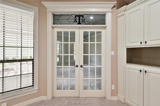 doorway to outside with light colored carpet and french doors