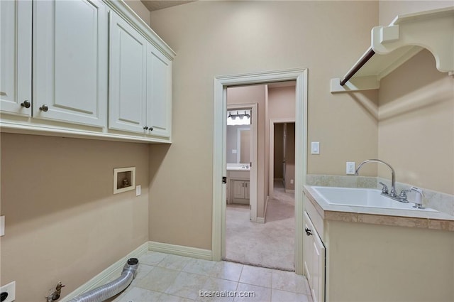 laundry area featuring cabinets, washer hookup, light tile patterned flooring, and sink