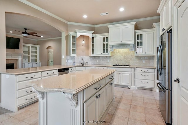 kitchen with ceiling fan, kitchen peninsula, decorative backsplash, white cabinets, and appliances with stainless steel finishes