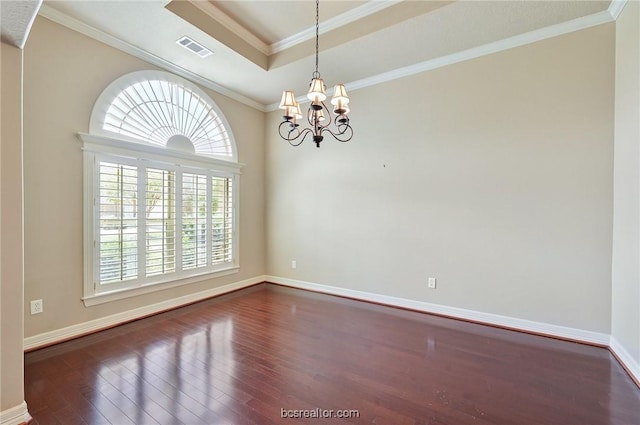 spare room with dark hardwood / wood-style floors, ornamental molding, and an inviting chandelier