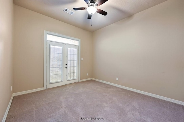 carpeted empty room with ceiling fan and french doors