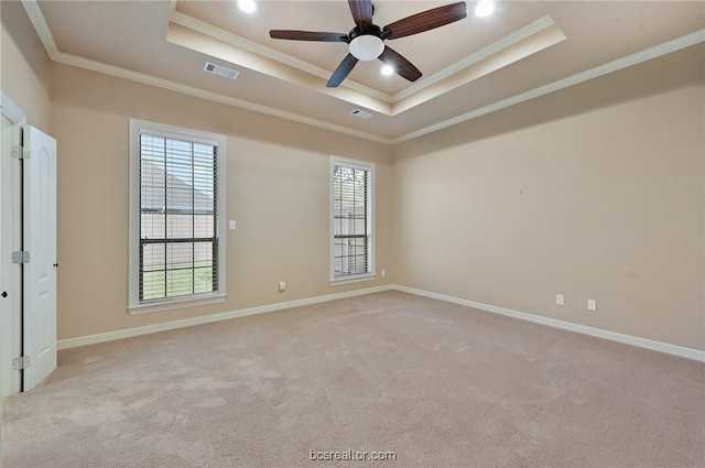 carpeted empty room featuring a tray ceiling, ceiling fan, and crown molding