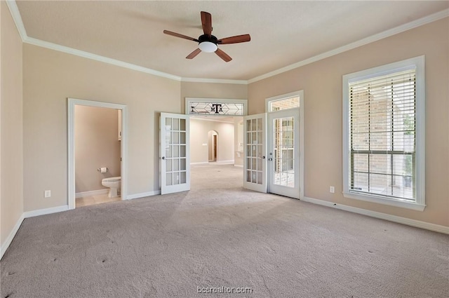 carpeted spare room with ceiling fan, french doors, and ornamental molding