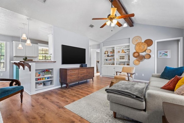 living room with vaulted ceiling with beams, ceiling fan, and hardwood / wood-style floors