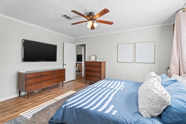 bedroom with wood-type flooring, a textured ceiling, ceiling fan, and ornamental molding