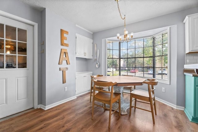 dining room featuring hardwood / wood-style floors, a textured ceiling, and an inviting chandelier