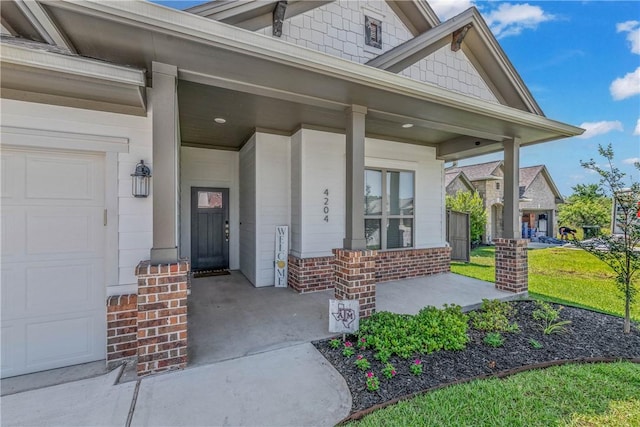 entrance to property featuring covered porch and a garage