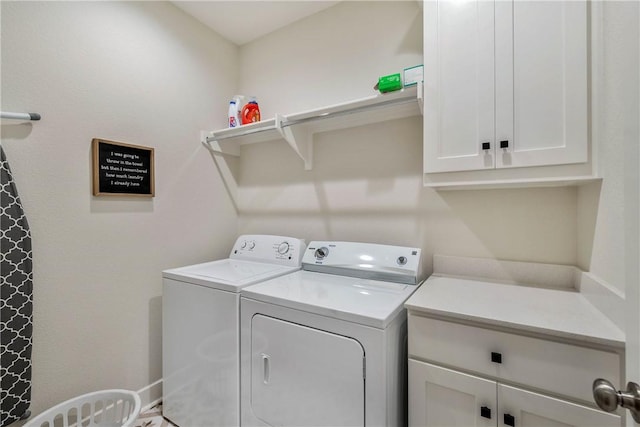 clothes washing area featuring washer and dryer and cabinets