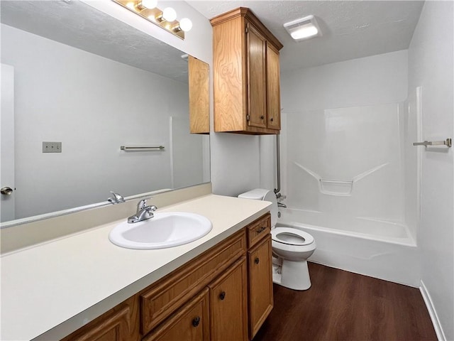 full bathroom featuring hardwood / wood-style floors, vanity, toilet, a textured ceiling, and shower / bathtub combination