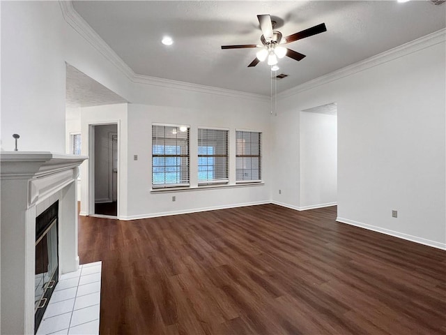 unfurnished living room with hardwood / wood-style flooring, ceiling fan, ornamental molding, and a tile fireplace