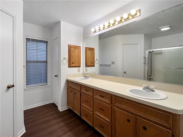 bathroom with vanity, wood-type flooring, a textured ceiling, and walk in shower