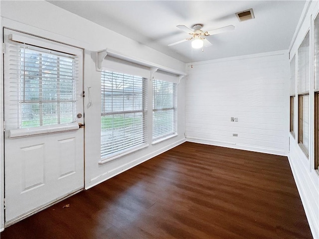 interior space featuring a wealth of natural light, ceiling fan, and dark wood-type flooring