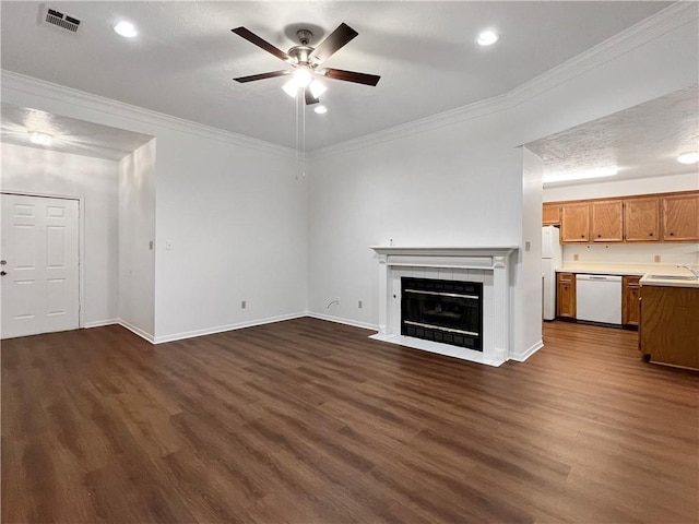 unfurnished living room featuring sink, dark hardwood / wood-style floors, ornamental molding, and a tiled fireplace