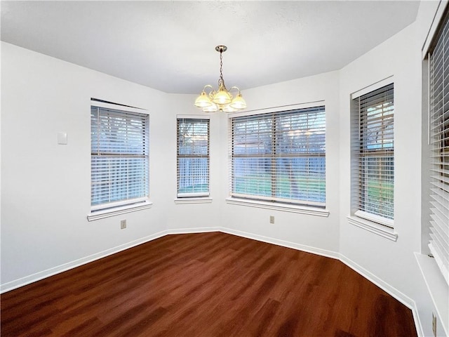 unfurnished room with wood-type flooring and a chandelier