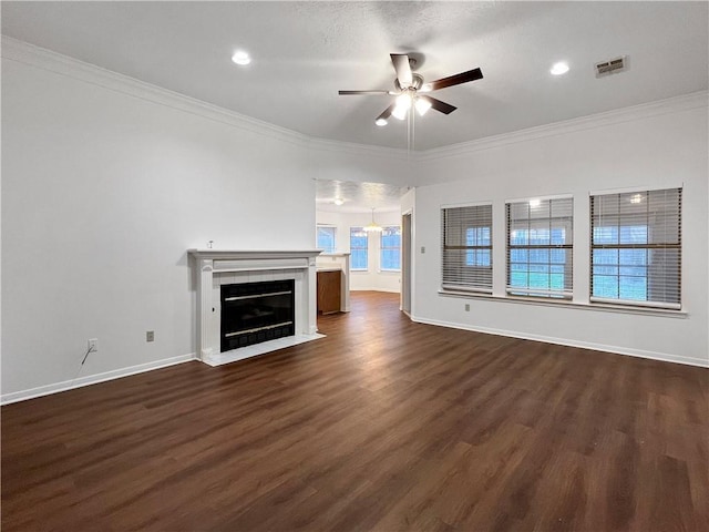 unfurnished living room with a fireplace, dark hardwood / wood-style floors, ceiling fan, and crown molding