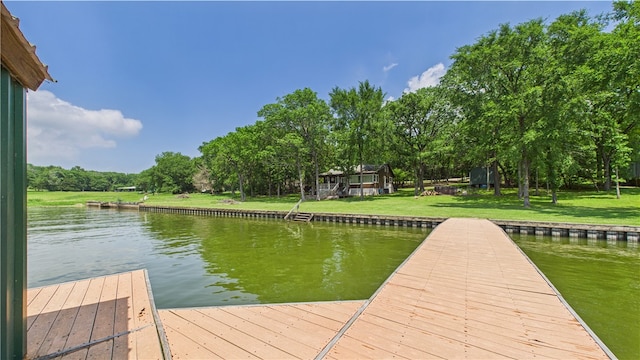 dock area featuring a lawn and a water view
