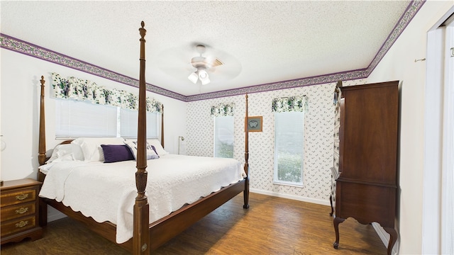 bedroom with crown molding, baseboards, a textured ceiling, and wood finished floors
