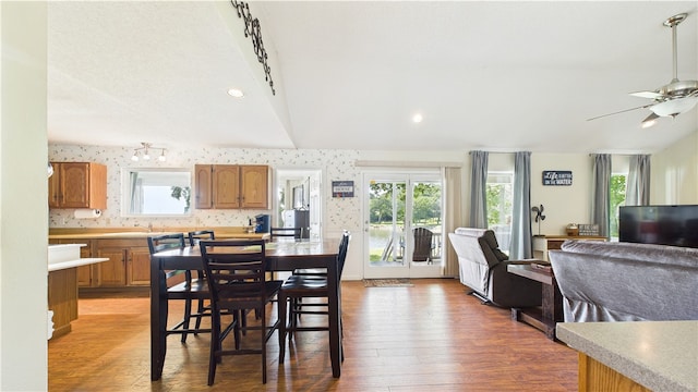 dining area with light wood-type flooring, ceiling fan, and a healthy amount of sunlight
