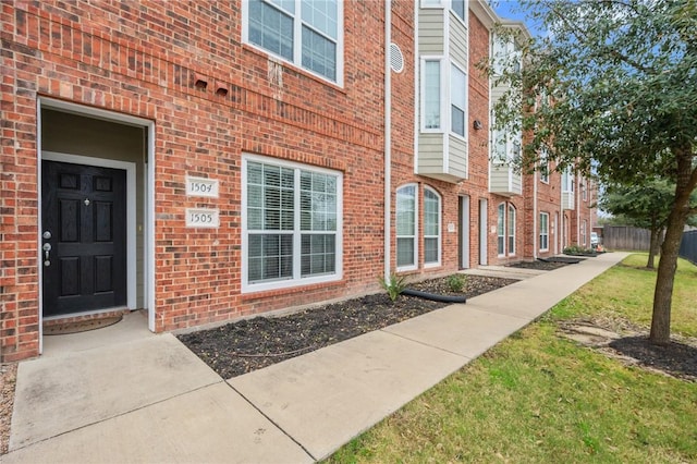 view of exterior entry with a lawn