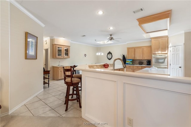 4718 Stonebriar Cir, College Station, TX 77845 - kitchen with a kitchen bar, ceiling fan, light tile patterned floors, and ornamental molding