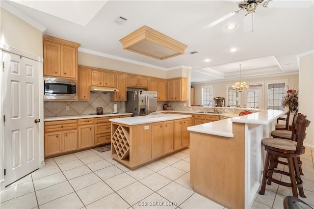 4718 Stonebriar Cir, College Station, TX 77845 - kitchen featuring kitchen peninsula, a breakfast bar, stainless steel appliances, a kitchen island, and hanging light fixtures