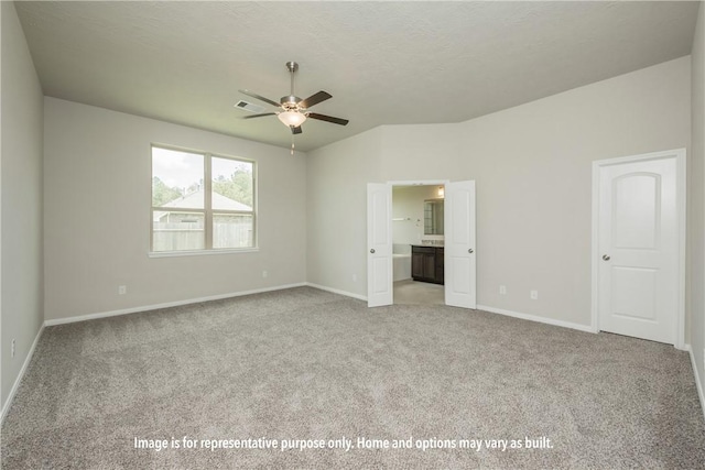 unfurnished bedroom featuring light carpet, ensuite bathroom, and ceiling fan