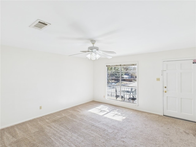 empty room featuring baseboards, a ceiling fan, visible vents, and light colored carpet