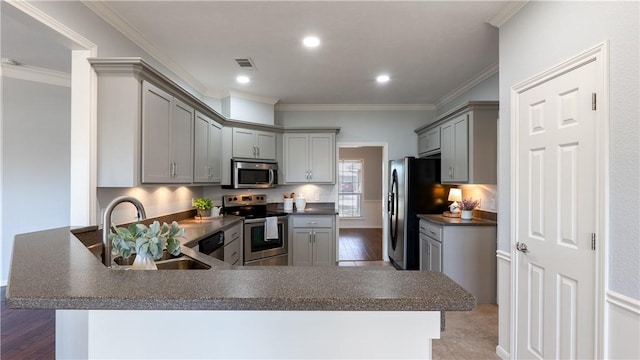 kitchen featuring dark countertops, visible vents, gray cabinets, appliances with stainless steel finishes, and a sink