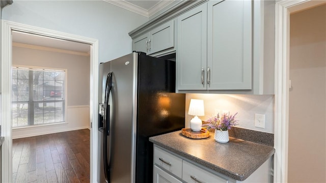 kitchen featuring dark countertops, ornamental molding, dark wood-type flooring, and stainless steel fridge with ice dispenser