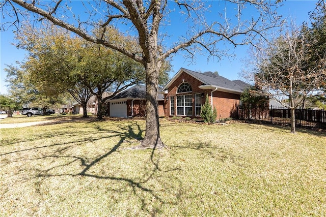 exterior space with brick siding, a front lawn, a garage, and fence