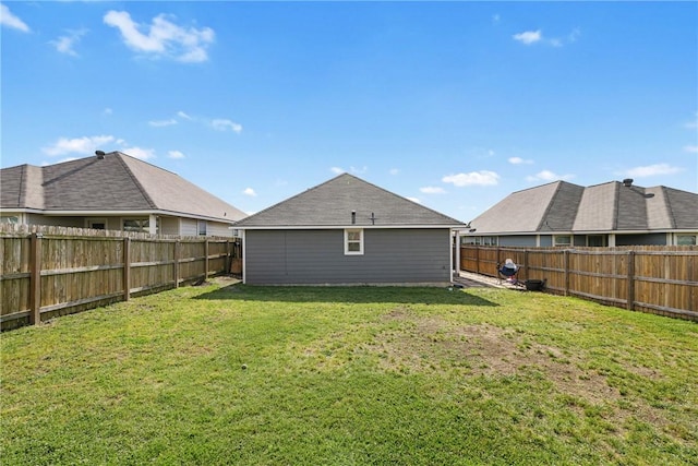 back of house with a lawn and a fenced backyard