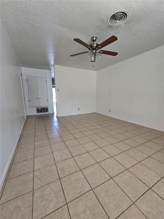 interior space featuring ceiling fan and a textured ceiling