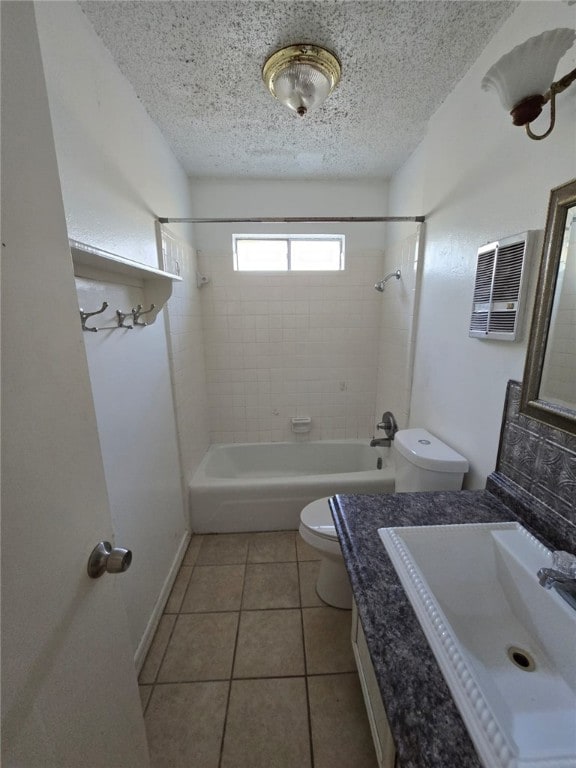 full bathroom with tile patterned floors, tiled shower / bath combo, a textured ceiling, and toilet