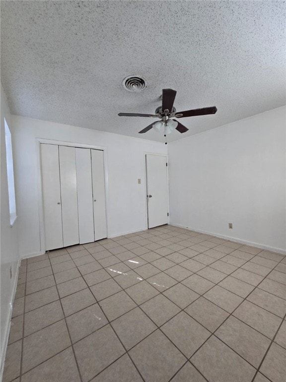 tiled spare room featuring ceiling fan and a textured ceiling