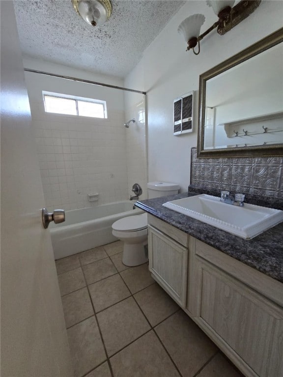 full bathroom with vanity, tile patterned flooring, tiled shower / bath combo, toilet, and a textured ceiling