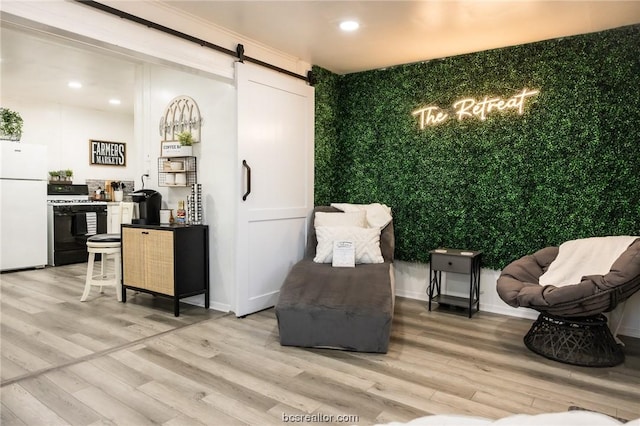 living area featuring a barn door and light hardwood / wood-style flooring