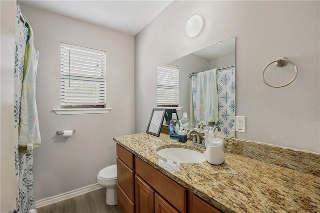 bathroom with wood-type flooring, vanity, and toilet