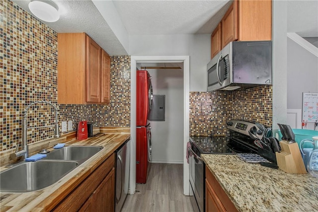 kitchen featuring sink, light hardwood / wood-style flooring, a textured ceiling, tasteful backsplash, and stainless steel appliances