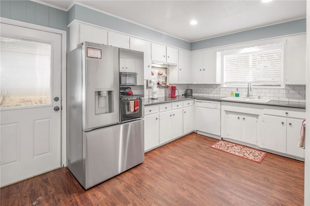 kitchen featuring dark wood-type flooring, sink, stainless steel fridge with ice dispenser, dishwasher, and white cabinets